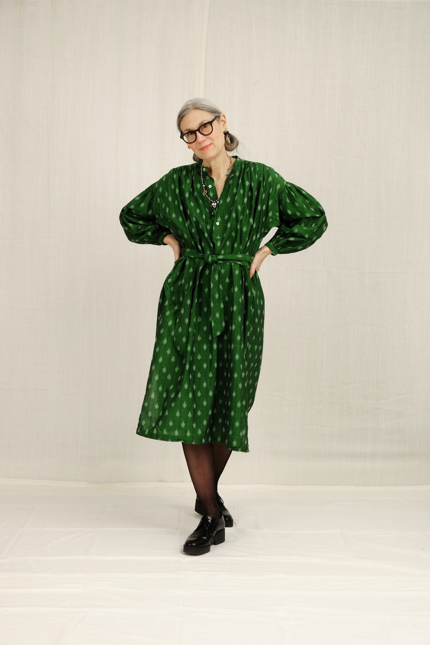 model wearing green belted dress