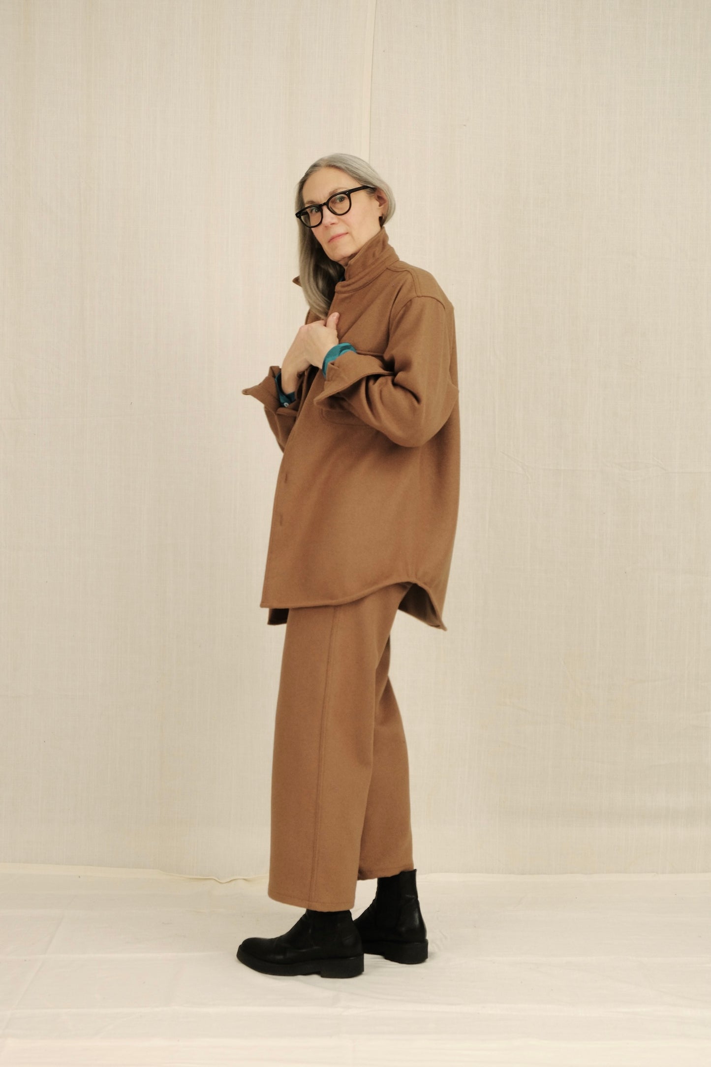 Person wearing a brown outfit with a plain background