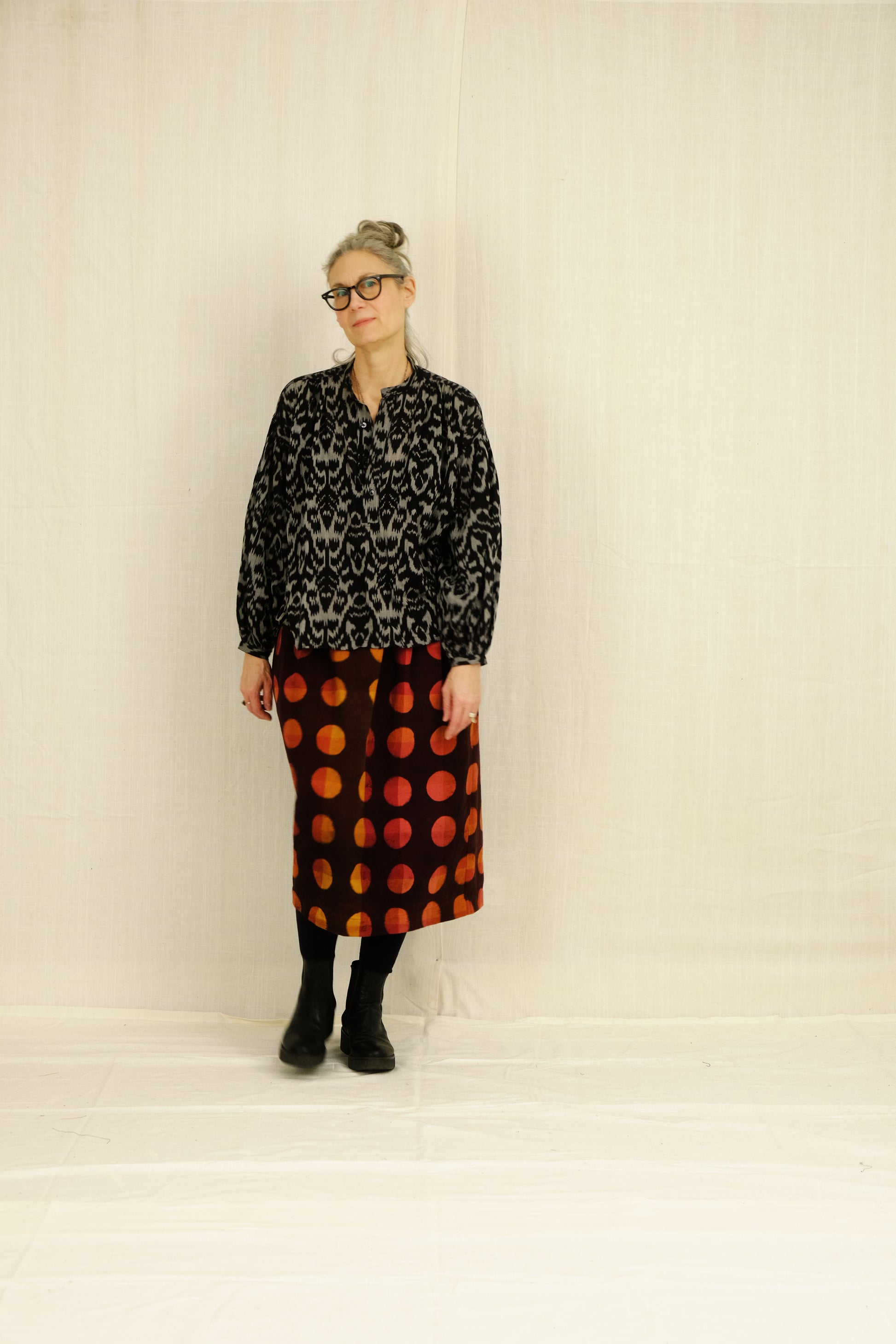 Person wearing a black ikat bpeasant blouse and skirt on a plain background