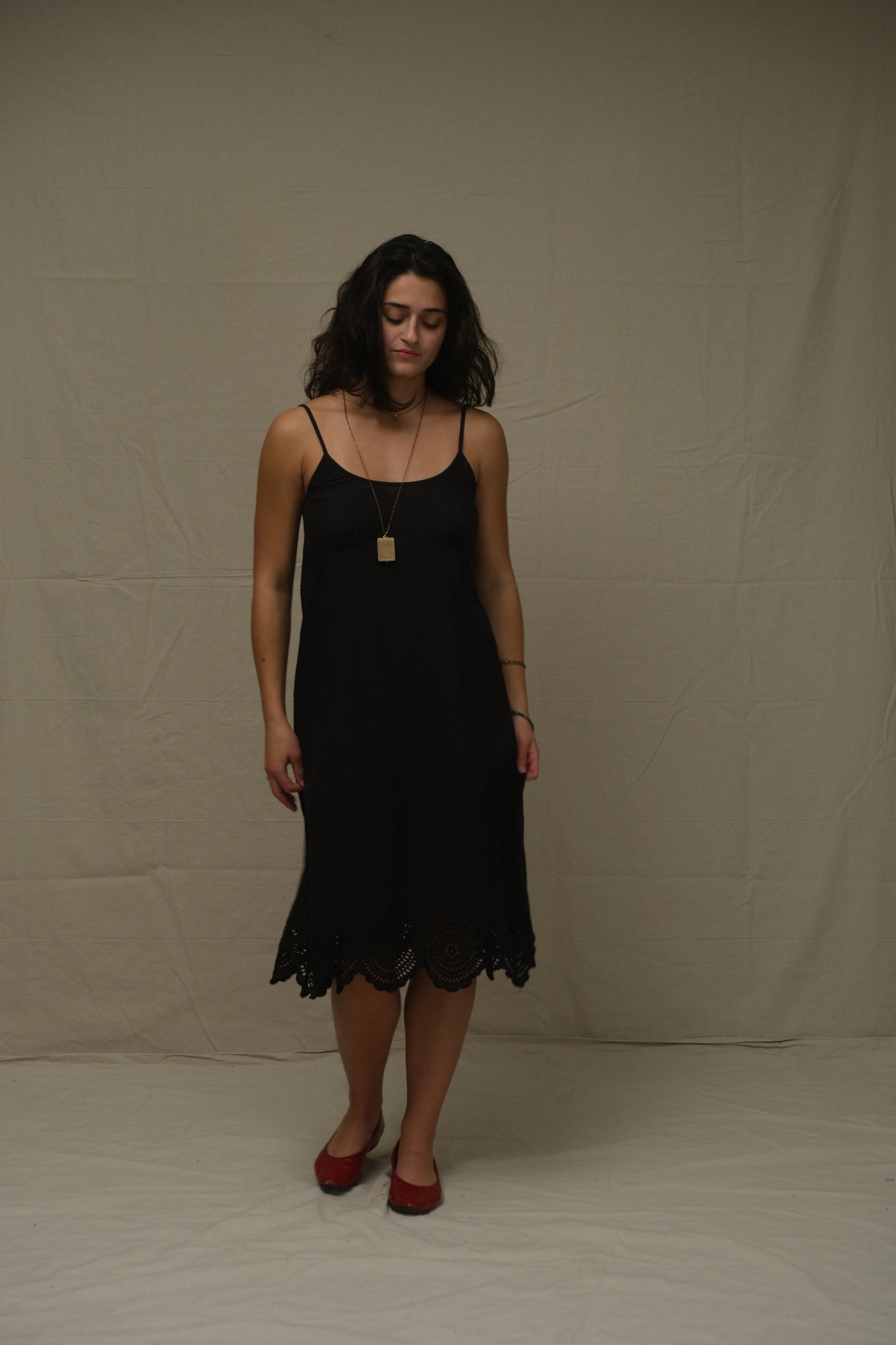 Woman wearing a black dress standing on a plain background