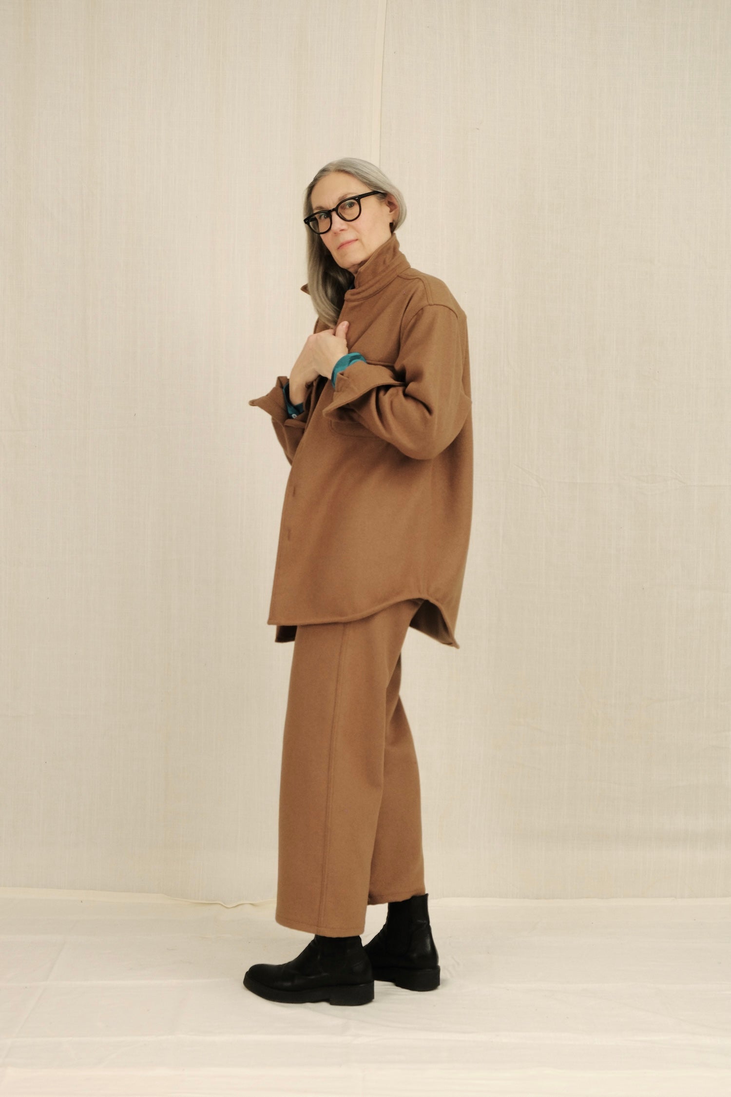 Person wearing a brown outfit with a plain background